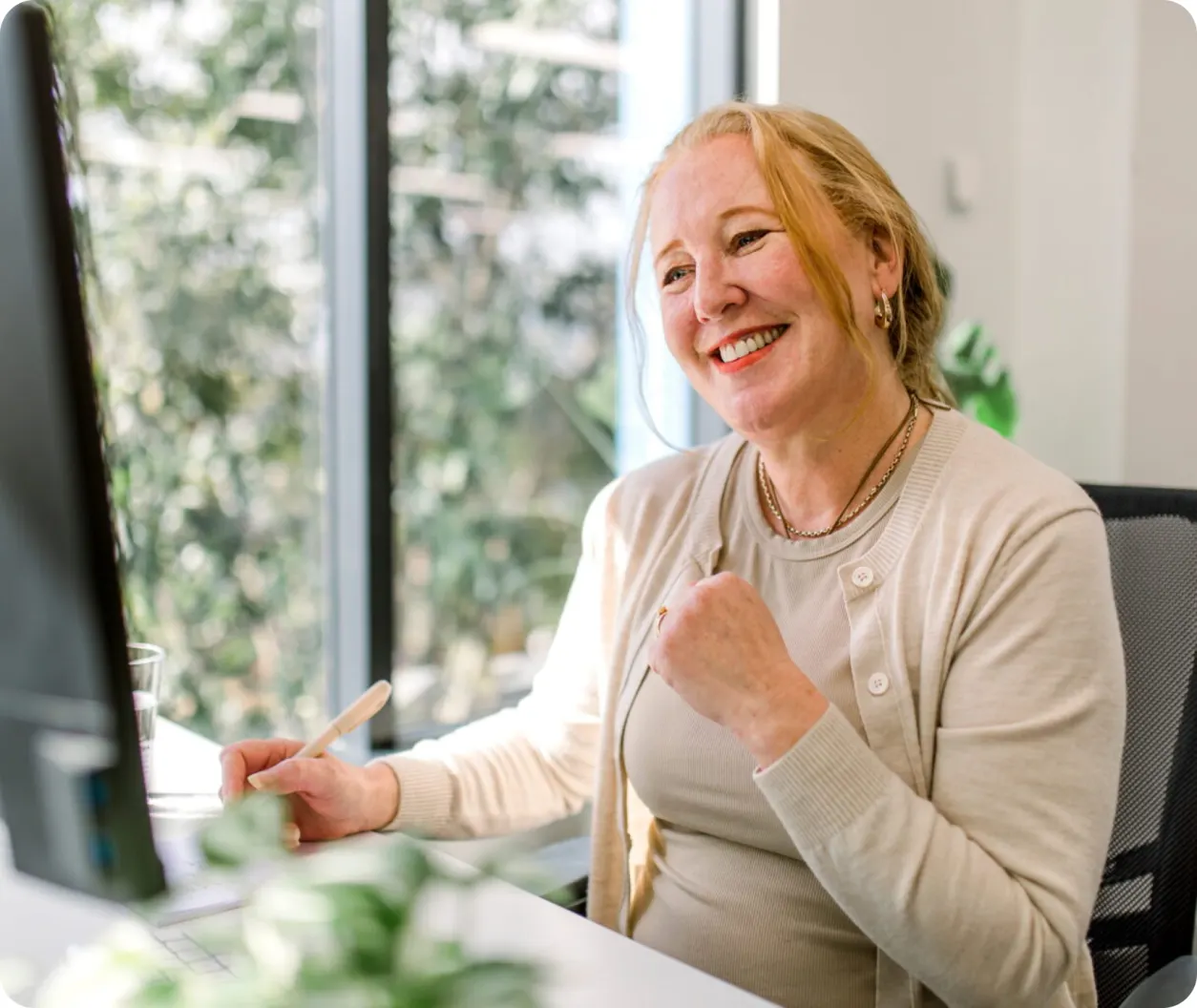 Clinician smiling at her computer during an online session